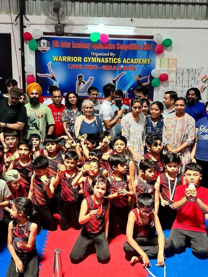 A group photo with all the participants, parents, and coaches after our 5th gymnastics competition. It's a community effort.