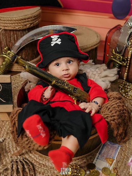 Aye, Captain Cutie! This little pirate is ready to set sail for adventure in our treasure-filled pirate ship set, a fun theme for a milestone session.