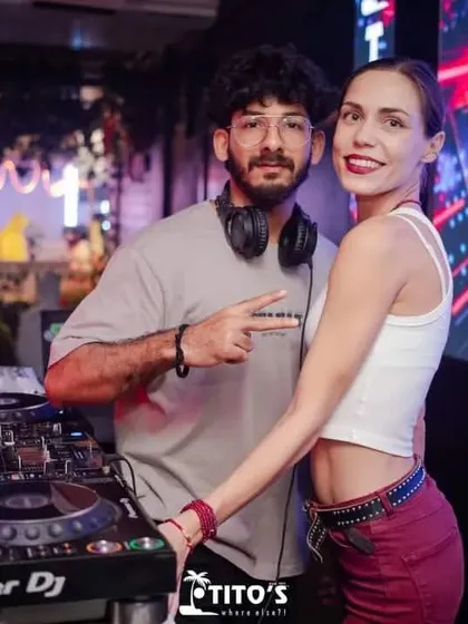 Posing with a guest by the DJ booth at Tito's. I always make time to connect with the people who come to enjoy the music and the party.
