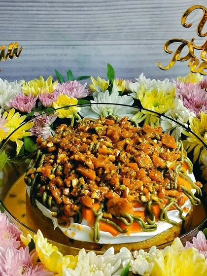 A centered shot of the Mango Pistachio Tres Leches hamper, highlighting the vibrant colors of the flowers and the rich texture of the cake's topping.