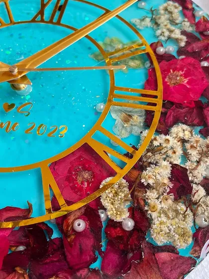 I love the drama of this 12-inch wall clock. The bright turquoise resin contrasts beautifully with the deep red and white preserved flowers, creating a very striking piece.