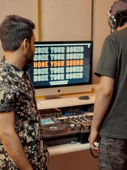 We use the studio's full capabilities during training. Here, a student and I are analyzing a waveform on screen while referencing the track on the decks, a key part of learning to mix visually and by ear.