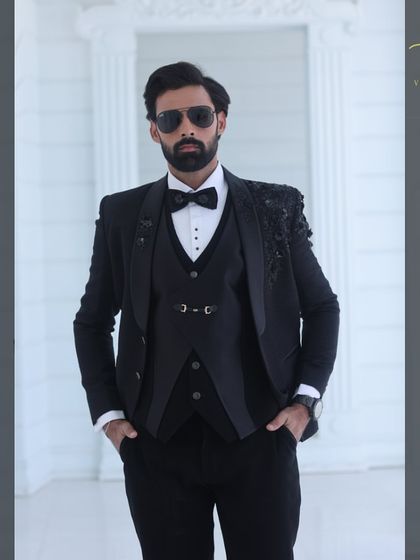 A classic pose in the black embroidered tuxedo, perfect for any formal wedding event.