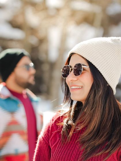 A beautiful candid shot of the bride smiling, with her partner in the background, during their Sissu valley photoshoot.