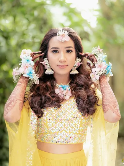 A portrait of the bride holding her floral haath phool. The mix of pink and blue orchids with baby's breath creates a fresh and modern look.