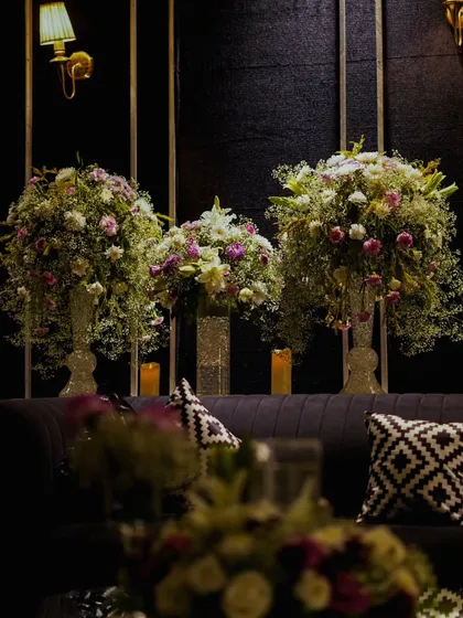 A view of the lounge seating, where the softness of the floral arrangements contrasts beautifully with the dark sofas and geometric-patterned cushions.