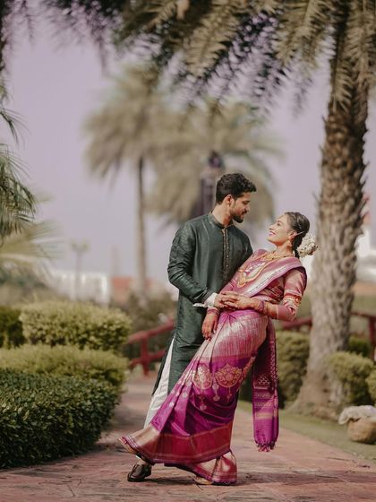 A graceful portrait of a South Indian couple. The groom dips his bride, dressed in a beautiful silk saree, showcasing the elegance and romance of traditional Indian weddings.