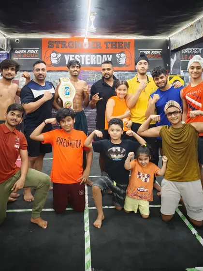 The team flexing their muscles and showing off a championship belt. We build champions from the ground up.