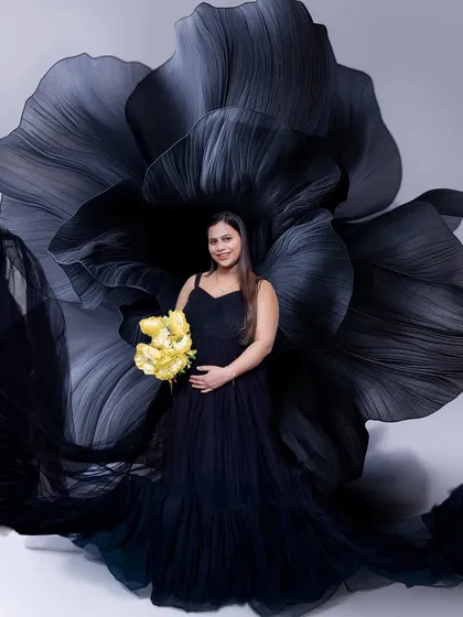 A classic black gown paired with a dramatic black flower backdrop for a touch of modern elegance. The pop of yellow from the flowers adds a beautiful, hopeful contrast.