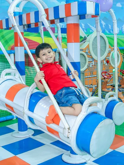A big smile from a happy boy on one of our themed swinging rides. All our equipment is padded and designed for safety.