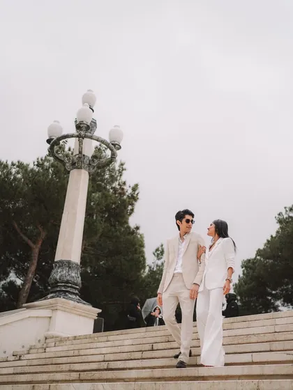 A classic, elegant shot of the couple descending a grand staircase in Baku. This image has a timeless, cinematic quality, perfect for a sophisticated pre-wedding album.