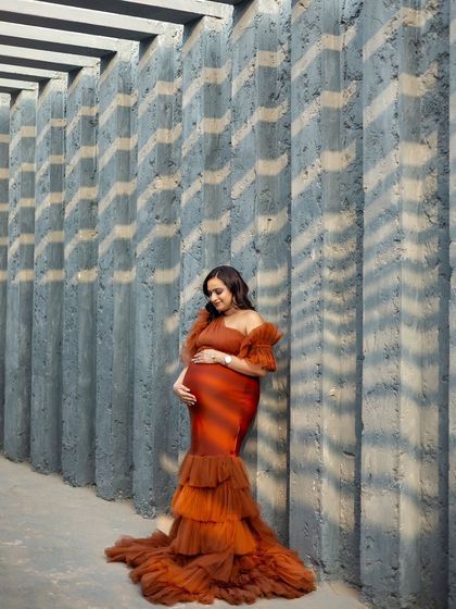 Our Bronze gown looks stunning against this modern, architectural backdrop. The play of light and shadow adds a dramatic effect.