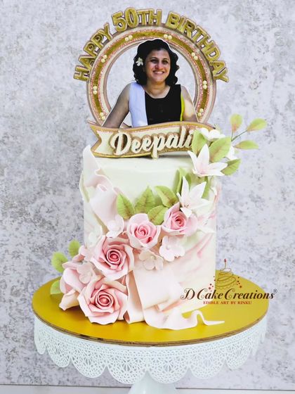 A studio shot of the beautiful 50th birthday cake, showcasing the soft textures and the personalized photo topper.