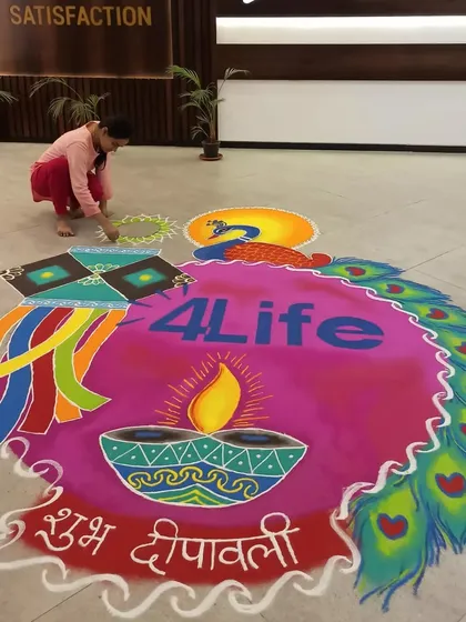 Here I am, putting the finishing touches on a large corporate rangoli. This shows the scale of my on-site work and the freehand process I use to create every detail, from the logo to the intricate peacock feathers.