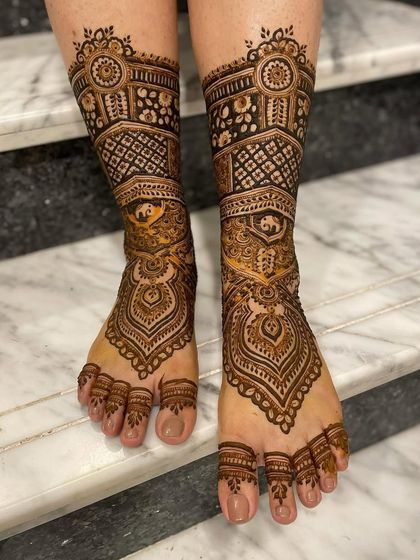 A classic and symmetrical bridal foot design. The patterns mirror each other perfectly, featuring a central paisley element and intricate bands that create a stunning overall look.