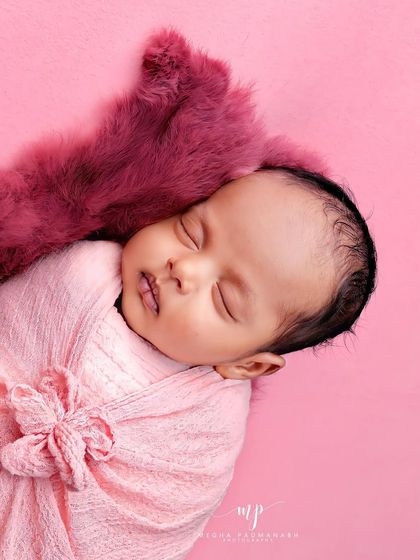 An overhead shot capturing the baby's peaceful sleep. The consistent pink color scheme is soft and soothing.