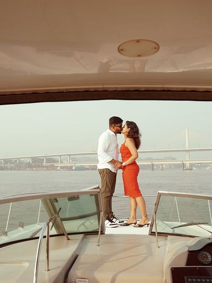 A romantic kiss on the bow of the yacht, perfectly framed by the boat's interior. This is a classic cinematic shot that combines intimacy with a grand setting.