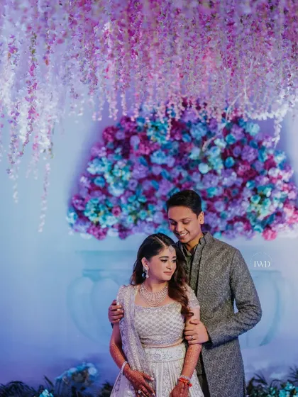 The diamond of the season. For this Bridgerton-inspired Sangeet, the couple poses against a stunning backdrop of cascading purple wisteria and a dense wall of hydrangeas, looking every bit the part of nobility.
