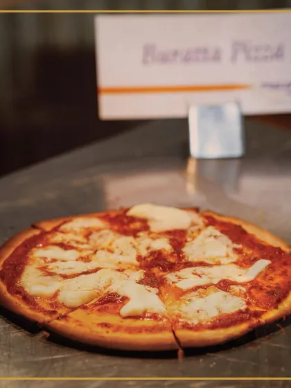 A close-up of our freshly baked Burrata Pizza, showcasing the melted, creamy cheese over a rich tomato sauce. A true slice of Mediterranean marvel.