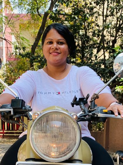 A graduate sits on her bike, the picture of happiness. She has unlocked a new level of freedom and fun.