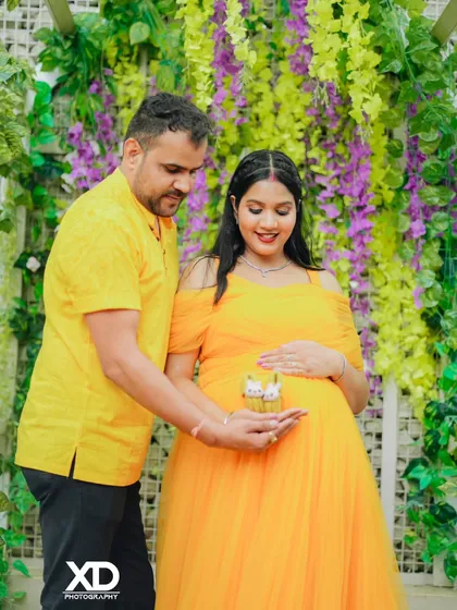 A tender moment as the couple looks down at a pair of tiny baby shoes held in their hands.