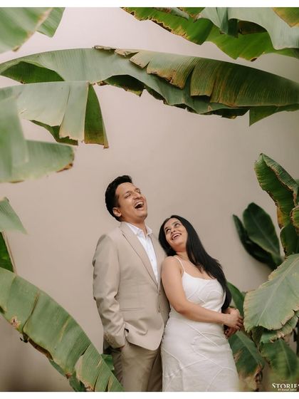 A moment of pure, uninhibited laughter shared between a couple, framed by large banana leaves. This candid shot from their Varanasi trip is full of life and joy.