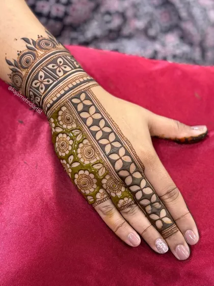 A modern design for the groom's sister, showing a mix of fresh and stained henna to highlight the pattern.