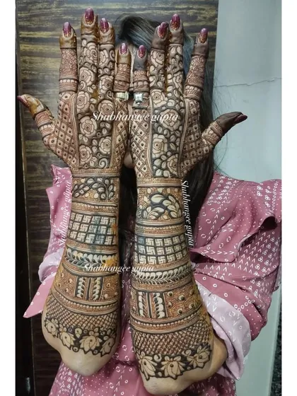 This is another example of a heavy, full-coverage back-of-hand design. It incorporates traditional elements like elephants and swastikas with intricate floral and geometric patterns.