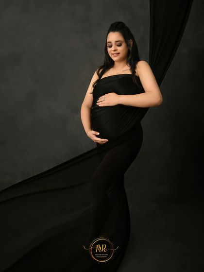 A simple and elegant portrait using a single piece of black fabric. This minimalist approach creates a timeless image that beautifully highlights the pregnancy silhouette.