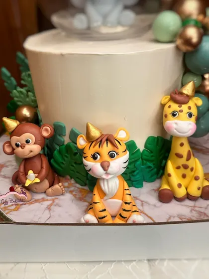 A close-up of the adorable, handcrafted sugar animals from the jungle dessert table. Each one is wearing a tiny party hat!