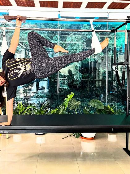 Beauty stays within. This playful and strong pose on the Cadillac trapeze table shows that fitness can be fun and empowering.