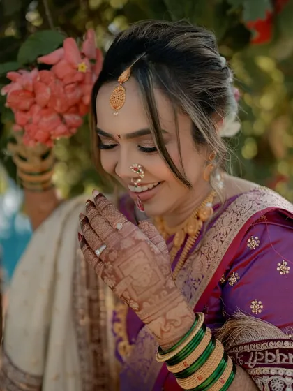 A joyful close-up of our Marathi bride. The subtle makeup, traditional nath, and green bangles all come together to create a stunning, authentic look.