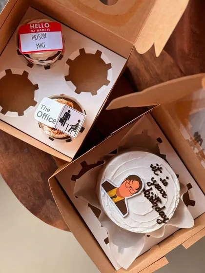 For the fans of "The Office," this themed set is a perfect birthday surprise. It includes a bento cake with a Dwight Schrute illustration and the iconic line "it is your birthday," along with matching cupcakes featuring other show references like the Prison Mike name tag.