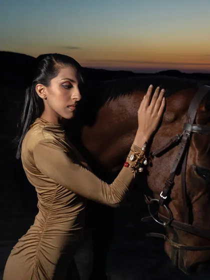 A side profile of a model gently touching a horse, showcasing elegant jewelry. The connection between the model and the animal adds a layer of emotion and storytelling to the photograph.