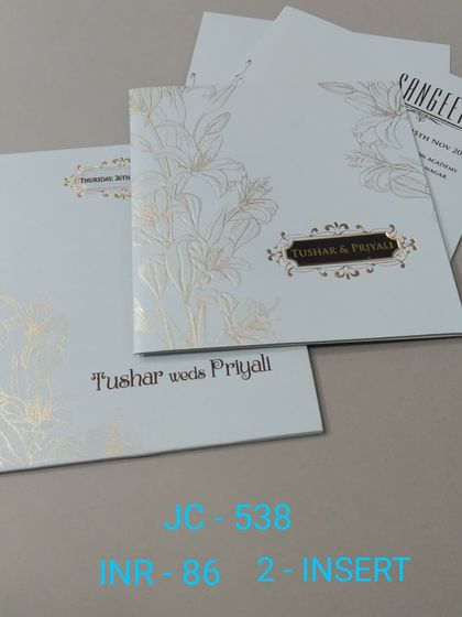 A simple and elegant white invitation with a gold foil lily design. The modern typography and clean layout make it a sophisticated choice for any event.