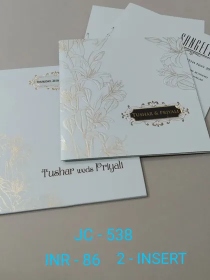 A simple and elegant white invitation with a gold foil lily design. The modern typography and clean layout make it a sophisticated choice for any event.