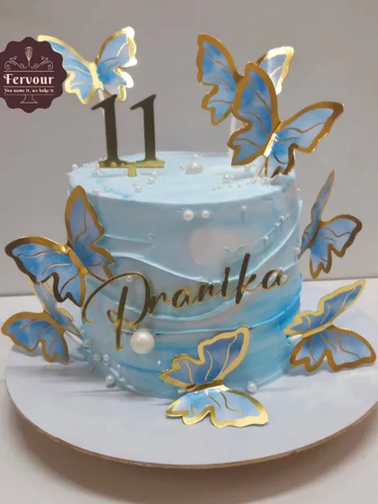 A butterfly theme cake in a beautiful shade of blue. This 1 kg chocolate truffle cake is decorated with delicate blue and gold butterflies.