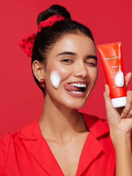 A playful and energetic shot where the simple red outfit allows the model's personality and the product to shine.