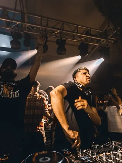 A wide shot of me and Ankytrixx on stage, with the crowd's hands in the air. We know how to work a room together and build an incredible atmosphere.