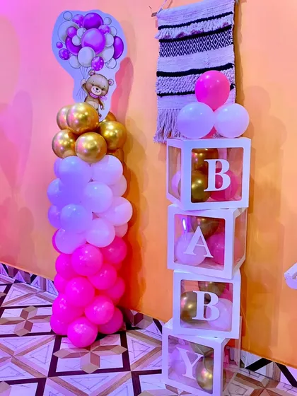 A cute 'BABY' block display and balloon pillar in pink, white, and gold, adding a sweet touch to a Naming Ceremony setup.
