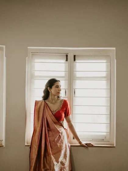 A quiet portrait of the bride by the window. This shot is part of our 'Detail Therapy' series, focusing on the small elements that make a look special, like the fall of a beautiful saree.