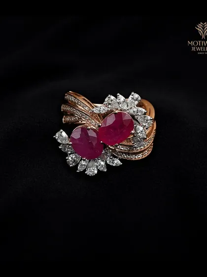 A romantic and bold design, this ring features two large pear-shaped rubies nestled amongst swirling bands of pave-set diamonds. A true statement of passion.