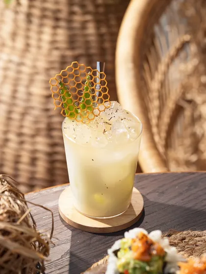 A light and refreshing cocktail with a honeycomb tuile. The bright, sun-drenched setting gives this a perfect beach-side, vacation feel.