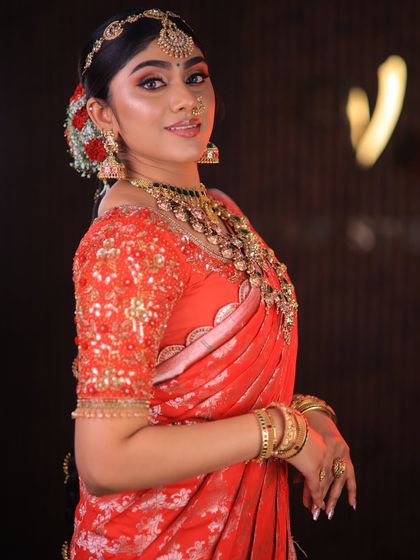 This stunning red floral saree is styled for a high-fashion bridal shoot. The drape is immaculate, designed to look dramatic and beautiful on camera.