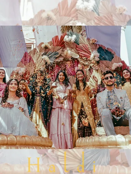 A vibrant group photo from a Haldi ceremony, with the couple and their loved ones showered in confetti.