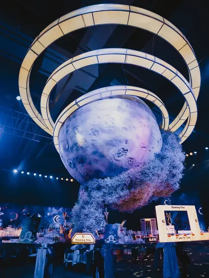 A giant, detailed moon installation suspended from the ceiling. This centerpiece was part of a celestial-themed event, creating a stunning focal point and reinforcing the cosmic vibe.