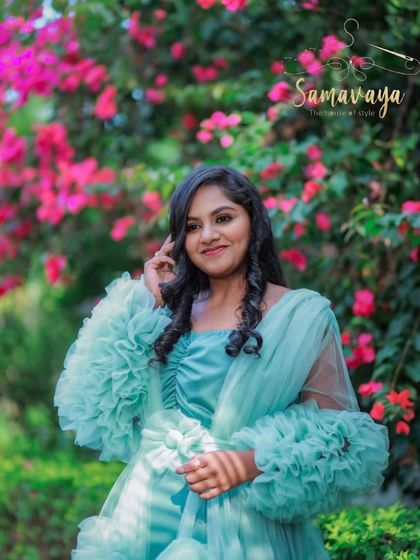 A close-up portrait in the garden, showing the intricate details of the gown and the mother's happy expression.