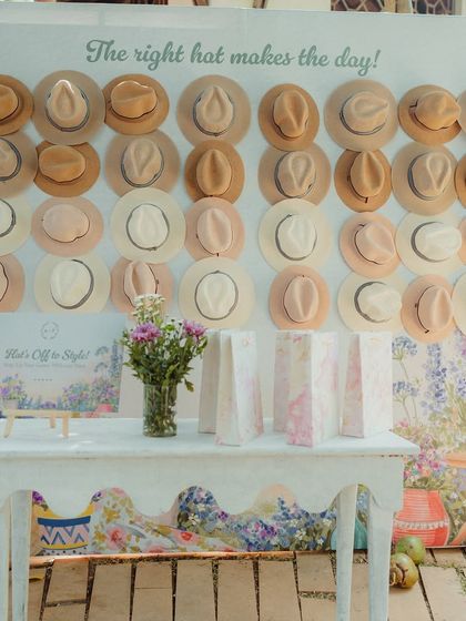 The full view of our "Hat Wall," a popular and stylish photo op that also served as a practical giveaway for the sun-drenched outdoor event.