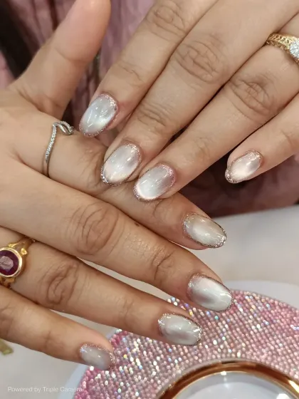 A beautiful set of oval nails featuring a pearly white cat-eye effect. I added a delicate silver glitter outline to each nail for a touch of sparkle and definition.