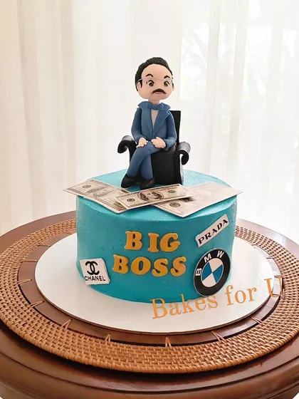 A "Big Boss" cake for an executive, featuring a custom fondant figure and logos of his favorite luxury brands like BMW, Chanel, and Prada.
